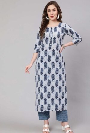 Image Alt Text A woman with long, wavy brown hair is standing against a plain grey background, modeling a light blue and navy blue printed straight kurta with three-quarter sleeves and a round neckline with a short button placket. She is also wearing matching printed trousers with a slightly darker blue geometric pattern at the hem.