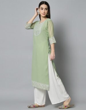 two-piece outfit consisting of a light green georgette kurti and white palazzo pants. The straight-fit kurti has three-quarter sheer sleeves and is heavily embroidered with intricate white floral patterns on the yoke and hem. The wide-legged white palazzo pants are flowing